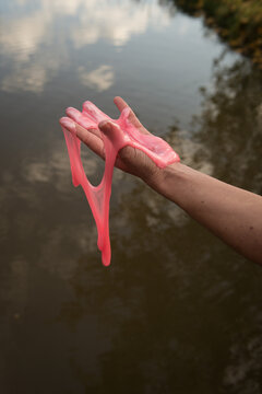 abstract art with hand on the water with pink dripping slime putty