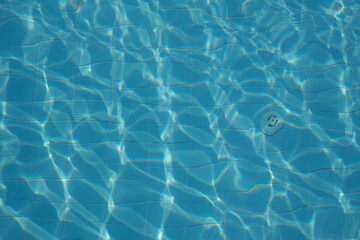 Sunlight patterns on azure pool tiles, serene and empty. Reflects growing interest in tranquil, minimalist design spaces.