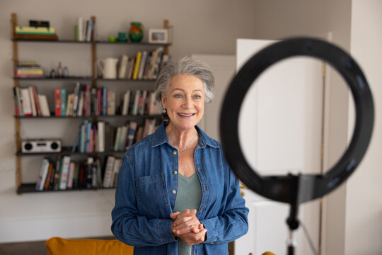 Senior female influencer recording a vlog at home