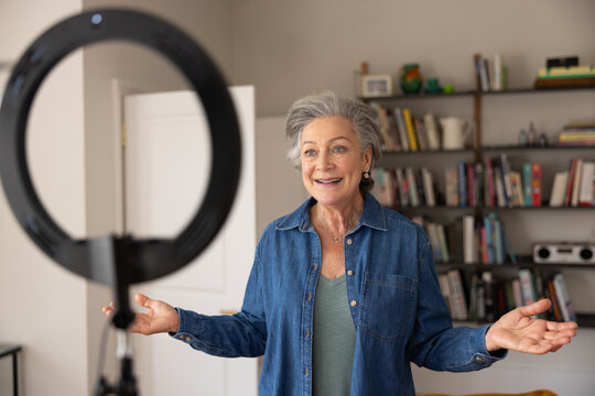 Senior female influencer recording a vlog at home