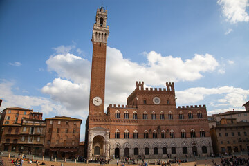 Obraz premium Tourists at Piazza del Campo and Palazzo Comunale, with er historic buildings in Siena, Italy 