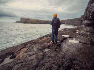 Tourist looking at stunning landscape of Aran island, county Galway, Ireland. Dark and dramatic...