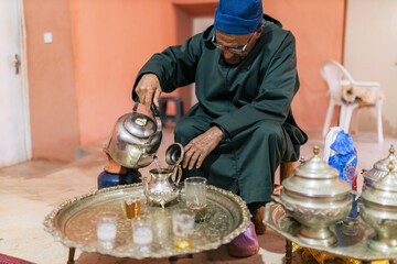 Man pouring water from kettle while making tea