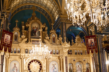 Golden altar and interior of the holy church with paintings of Maria, Joseph and Jesus - light from a golden chandelier - obrazy, fototapety, plakaty