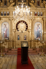Golden altar and interior of the holy church with paintings of Maria, Joseph and Jesus - light from a golden chandelier © mecron