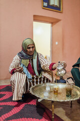 Muslim woman sitting while pouring refreshing tea