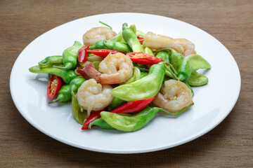 stir fried katuri flower with shrimp in a ceramic dish on wooden table, close up. asian homemade style food concept.