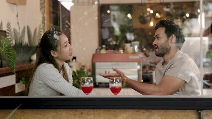Two male and female restaurant partnership start small business entrepreneur talking or dating in cafe against window, Multicultural Indian freelance husband and Asian wife happy spend time together