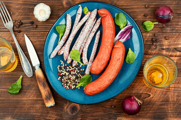 Thin kabanos sausages on wooden background.