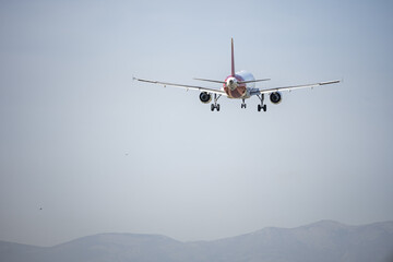 Fototapeta na wymiar An Airbus a321 approaching the runway to land at an airport with mountains in the background