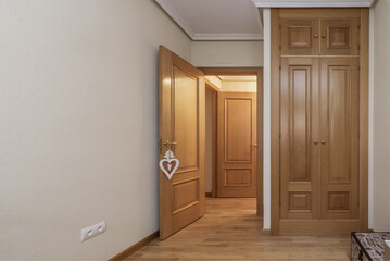 Built-in wardrobe in the bedroom with oak wood doors, floors of the same material and carpentry of...