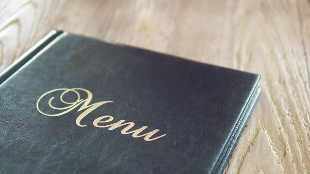 Close-up of an Elegant Restaurant Menu on a Dining Table in 4k slow motion 60fps