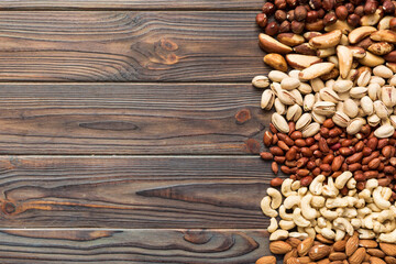 different nuts frame background. Close up, top view, flat lay with vopy space. Walnut, pistachios, almonds, hazelnuts and cashews