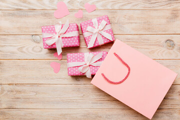 Gift boxes pop out from paper bag top view on colored background. bag packing handmade boxes fall out Concept of holidays, shopping, sale, discounts. Top view, flat lay