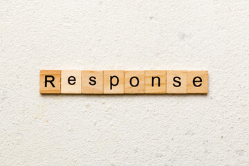 RESPONSE word written on wood block. RESPONSE text on cement table for your desing, concept