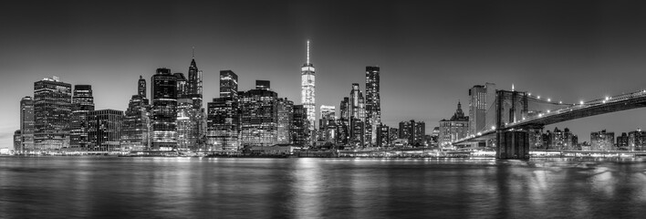 Panoramic view of New York City Lower Manhattan skyscrapers at twilight with the Brooklyn Bridge and East River (Black and White) - obrazy, fototapety, plakaty