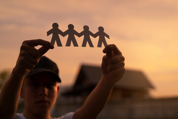Teamwork and relations. symbolic of paper chains in teenage boy hand. People are connected to each...