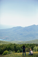 Fototapeta na wymiar Tourist traveler on top of mountain looking at landscape