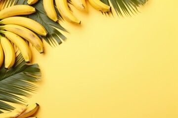 Beautiful and appetizing sweet golden bananas with green tropical leaves on clear yellow background with copy space. Summer freshness fruits. Healthy eating, raw food, vegan vitamins food concept