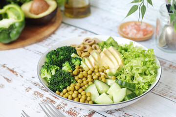 A bowl with a salad made of green vegetables