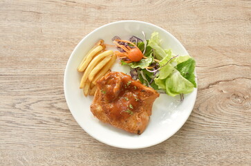 grilled chicken black pepper steak dressing spicy sauce with French fries and salad on plate 