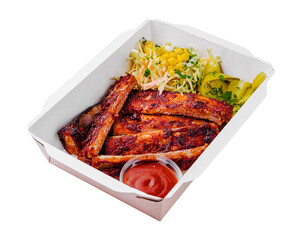 Tasty grilled ribs with vegetables in box