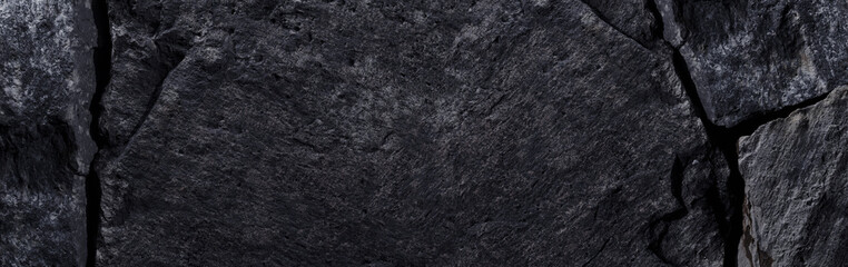 Black stone texture, dark abstract background. Natural mineral rock close up details, empty backdrop with copy space for design