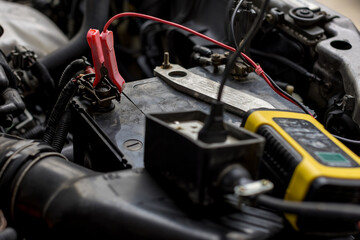 Engine engineer is recharging car battery because car battery is depleted. concept car maintenance.