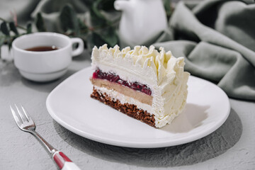 Layered Mousse Cake on white plate and cup of tea