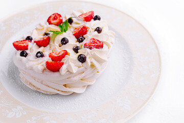Pavlova cakes with cream and fresh berries on plate
