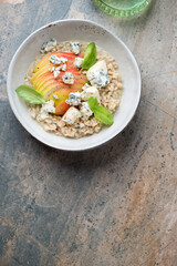 Pear and blue cheese risotto on a beige and grey granite background, vertical shot with copy space, above view