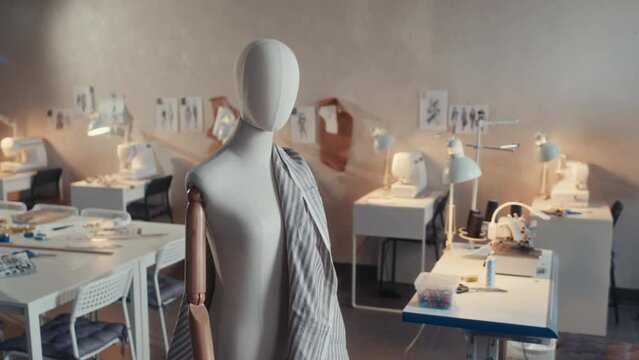 No people shot of white mannequin with striped textile or fabrics in empty modern atelier workshop