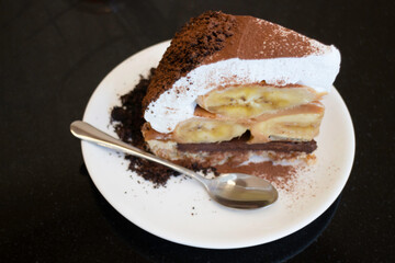 Banoffee cake with bananas and whipped cream in cafe restaurant