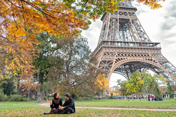 Couple having romantic picnic on Champ de Mars in view of Eiffel Tower