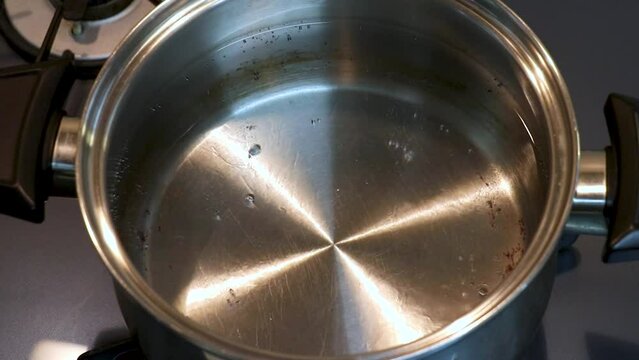 水が入った金属鍋をコンロで加熱する