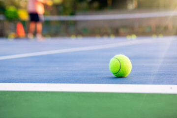 Tennis ball on a blue paddle tennis court