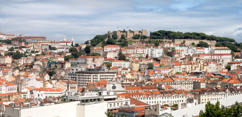 Naklejka na ściany i meble Panoramic view of the roofs of the Alfama district with St. George's Castle in the background (Lisbon)
