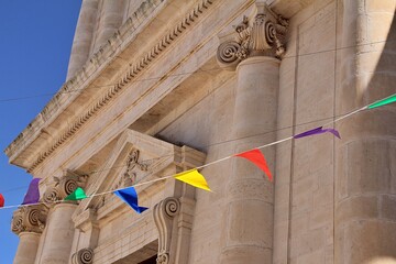 church building, columns, old building, Ionic columns, suspended colorful garlands, blue sky,...