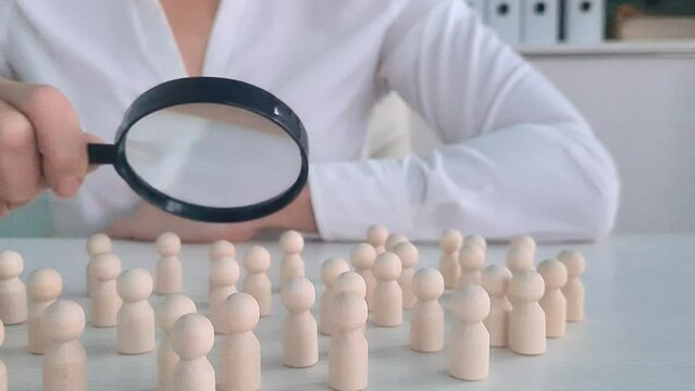 Businesswoman study crowd of people with magnifying glass. Searching for job candidates and recruiting personnel