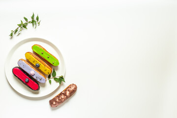 Set of various glased eclairs with chocolate and berrie, top view