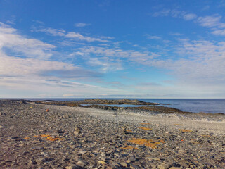 The rocky coast of the Barents Sea. Beautiful view of the rocks and the coast of the Rybachy and Sredny peninsulas, Murmansk region, Russia. The landscape is the harsh beauty of the north.