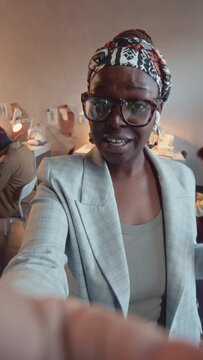 Vertical POV UGC of African American female creative director in glasses filming vlog and talking about ork process in atelier
