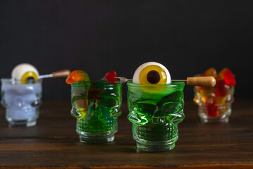 Halloween drinks over dark wooden background.