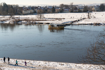 View of the city of Dresden and the Elbe River in winter. Ferry, crossing. Famous tourist spot