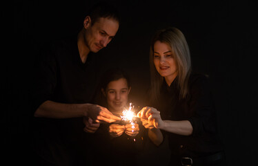 family with sparklers on a black background