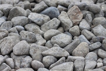 Large stones of different shapes on the riverbank close-up. there are a lot of small stones nearby.