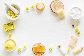 White and yellow chamomile flowers with herbal cosmetic beauty products