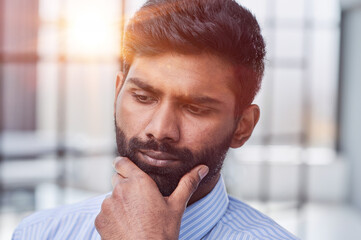 businessman or manager with a beard thinking while scratching his chin trying to come up with a...