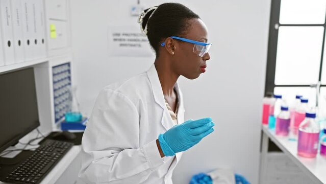 Attractive african american female scientist immersed in groundbreaking research, analysing sample under microscope in bustling lab.