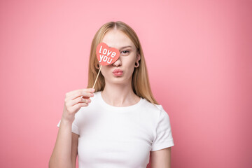 Portrait of attractive girl on pink background with red hearts for valentine's day. Concept of...